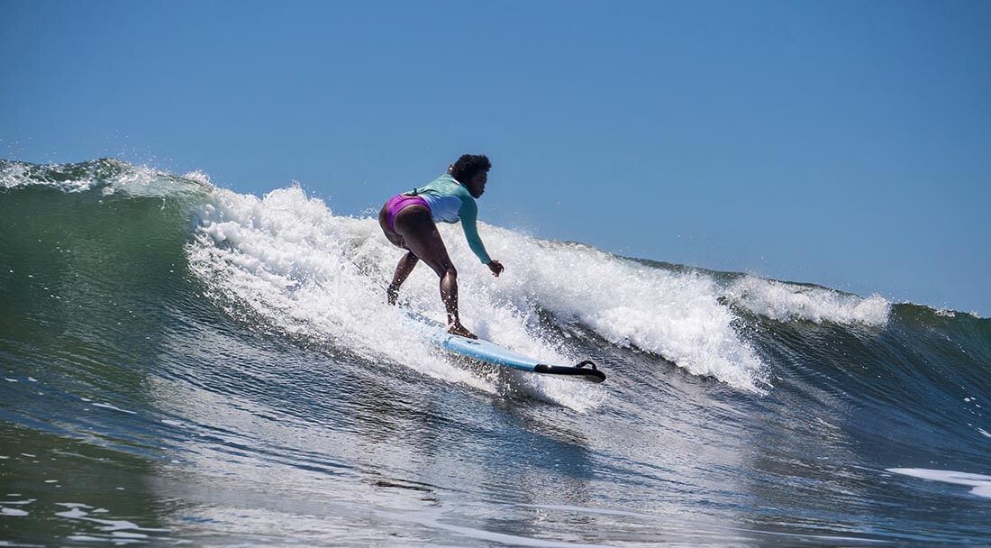 Surfer catching a big blue green wave