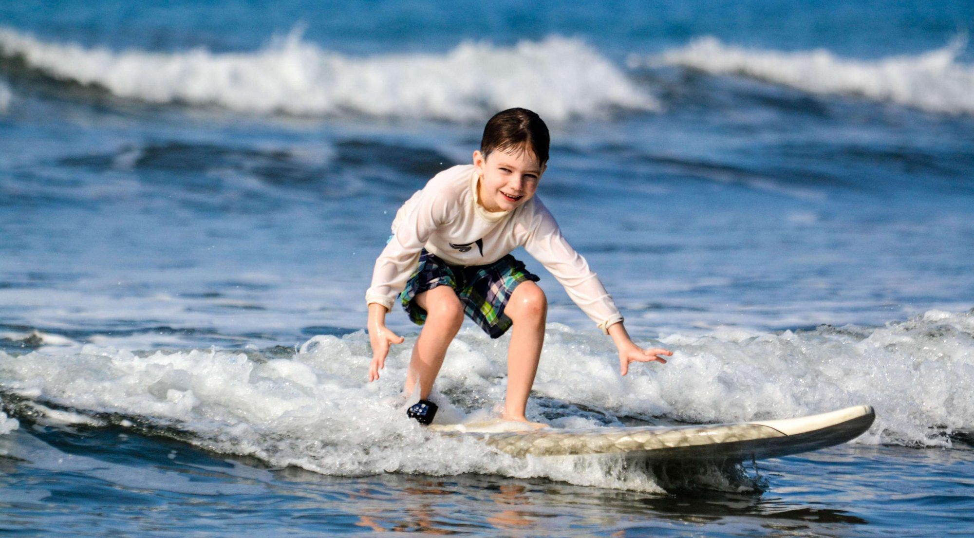 Child learning to surf in the whitewater