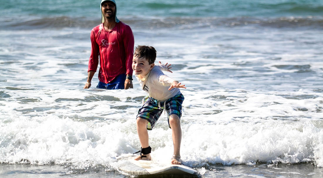 Young surfer is confident and smiling in the whitewater